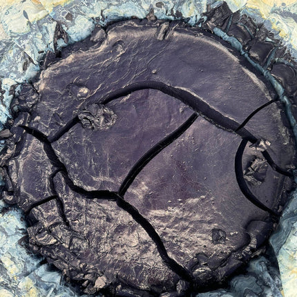 Close-up of cracked indigo dye on a textured beige background